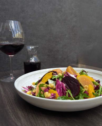 A Beet & Citrus salad with goat Cheese, chicory, lemon dijon, and hazelnut